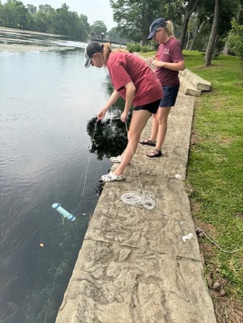 student doing experiment on river