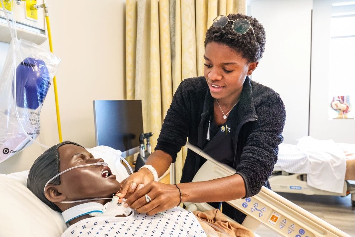 A TLU student nurse practices a procedure on a mannequin