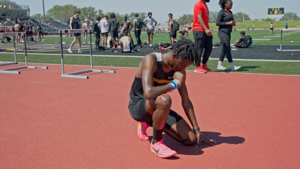 student praying at track meet