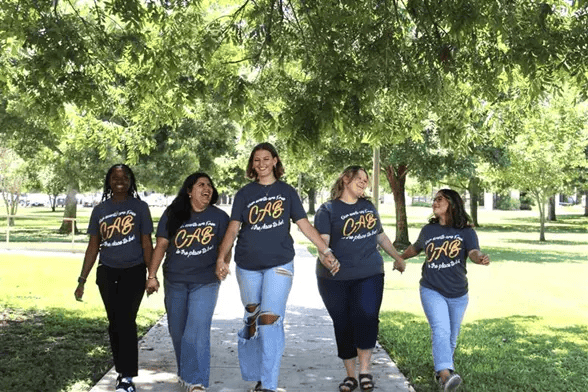 A diverse group of TLU women in matching TLU Campus Activities tee-shirts.