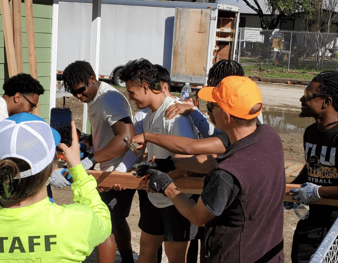 A group of TLU students and faculty working on a Housing project.