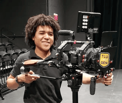 A student operates a television camera.