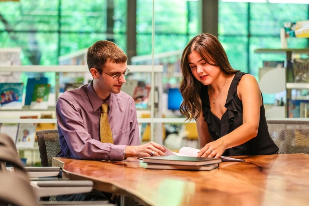 A student and her professor working in the library