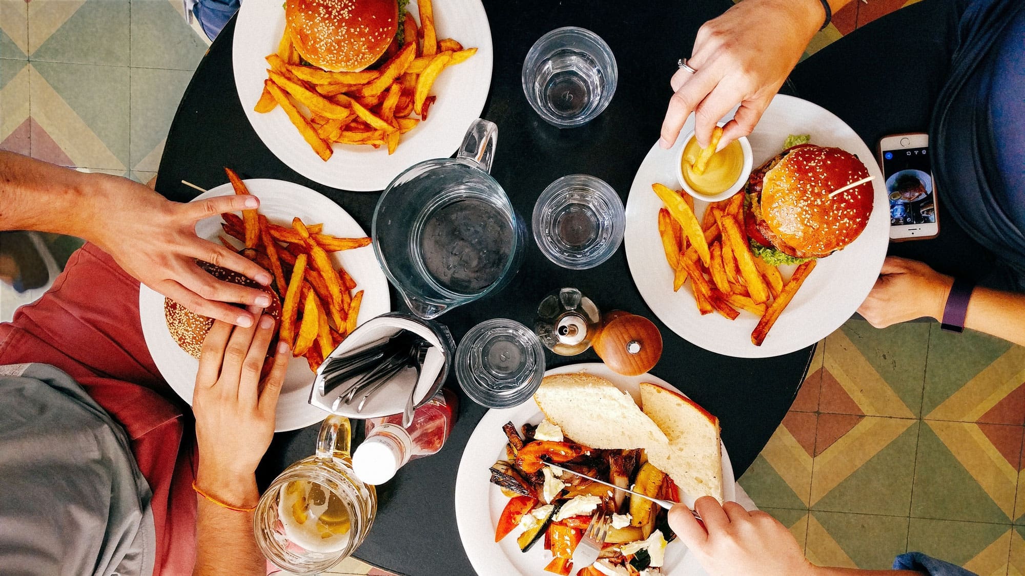 hands of students eating around a shared table